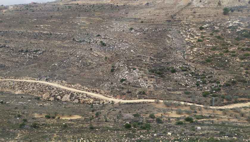 Photo of gravel road through arid land in Palestine.